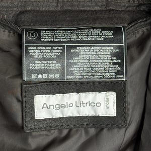 Puede incluir: Primer plano de una etiqueta de chaqueta de cuero marr&oacute;n oscuro. La etiqueta dice "Angelo Litrico" en texto blanco sobre un fondo negro. Texto adicional en la etiqueta detalla los materiales e instrucciones de cuidado de la chaqueta.