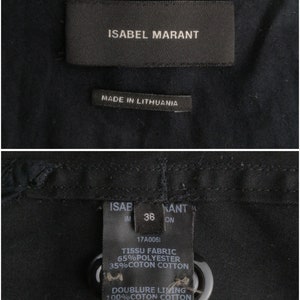 May include: Black fabric label with white text reading "ISABEL MARANT" and "MADE IN LITHUANIA". A second black fabric label with white text reads "ISAB KANT", "IM 36 ON", "17A0061", "TISSU FABRIC 65% POLYESTER 35%COTON COTTON", and "DOUBLURE LIVING 100% COTON COTTON".