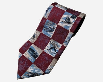 May include: A red and white patterned silk tie featuring a repeating design of skiers and snowboarders on a snowy mountain landscape.