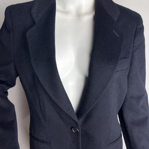 Pode incluir: Um blazer azul escuro com um fecho de bot&atilde;o &uacute;nico e lapela de entalhe.