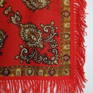 K&ouml;nnte beinhalten: Roter Schal mit Paisley-Muster und Fransenrand. Der Schal hat ein traditionelles Design mit braunen und goldenen Akzenten.