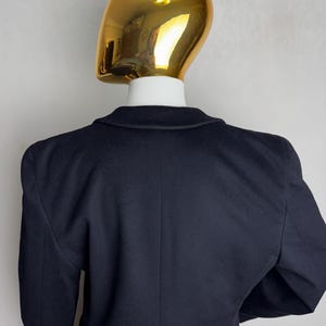 Pode incluir: Um blazer azul marinho com um design cl&aacute;ssico. O blazer tem um fecho de um s&oacute; bot&atilde;o e mangas compridas.