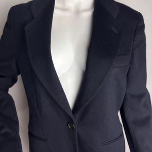 Pode incluir: Um blazer azul escuro com um &uacute;nico bot&atilde;o de fecho e lapela de entalhe.