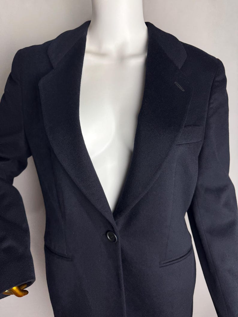 Pode incluir: Um blazer azul escuro com um &uacute;nico bot&atilde;o de fecho e lapela de entalhe.