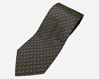 Puede incluir: Una corbata de seda azul oscuro con un patrón repetido de círculos dorados entrelazados y pequeñas estrellas blancas.