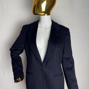 Pode incluir: Um blazer azul marinho com um fecho de bot&atilde;o &uacute;nico e uma lapela cl&aacute;ssica.