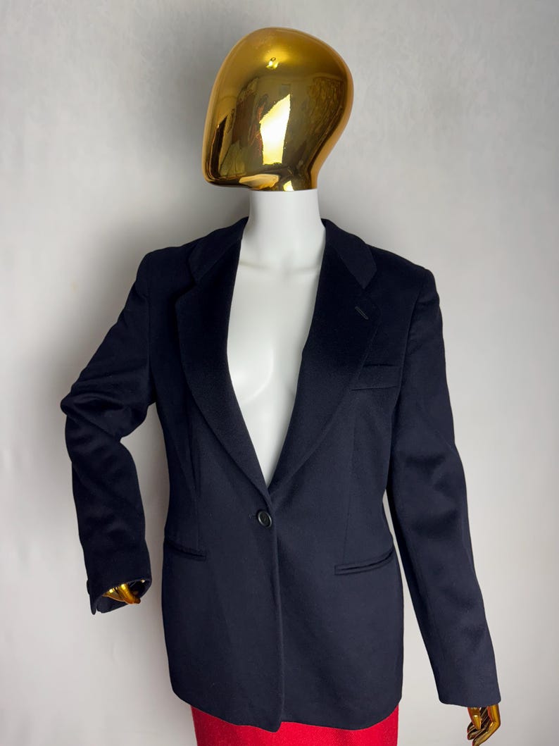 Pode incluir: Um blazer azul marinho com um fecho de bot&atilde;o &uacute;nico e uma lapela cl&aacute;ssica.