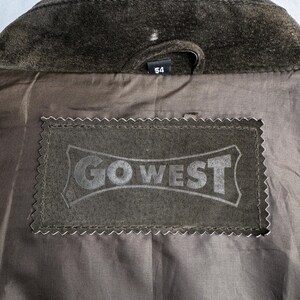 May include: A brown suede jacket with a label that says "GO WEST" and a size tag that says "54".