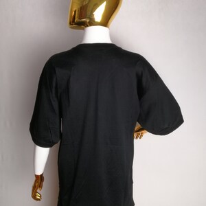 May include: Black short-sleeved t-shirt with a crew neck.