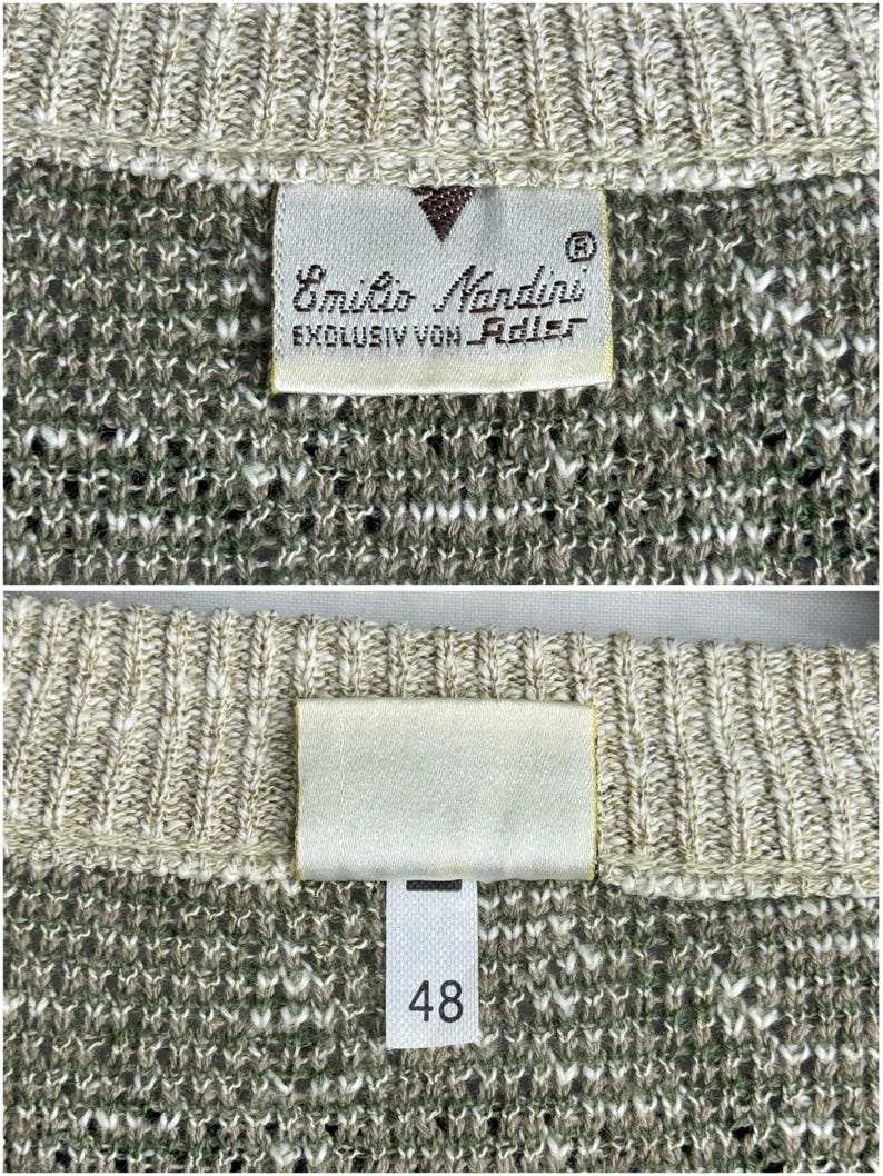 May include: Close-up of a knit sweater with a tag that reads "Emilio Nandini EXCLUSIV VON Adler". The sweater is a mix of beige, green, and white threads. The tag also has a size label with the number 48.