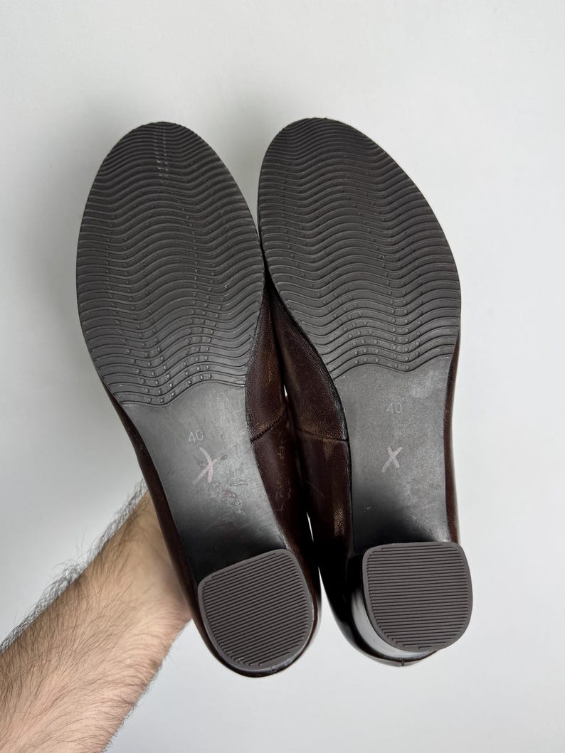 Puede incluir: Un par de zapatos de cuero marr&oacute;n con tac&oacute;n bajo. Las suelas son de color marr&oacute;n oscuro con un patr&oacute;n ondulado. Los tacones son de color marr&oacute;n oscuro. Talla 40.