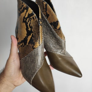 May include: A pair of brown and black snakeskin ankle boots with pointed toes and a stiletto heel.