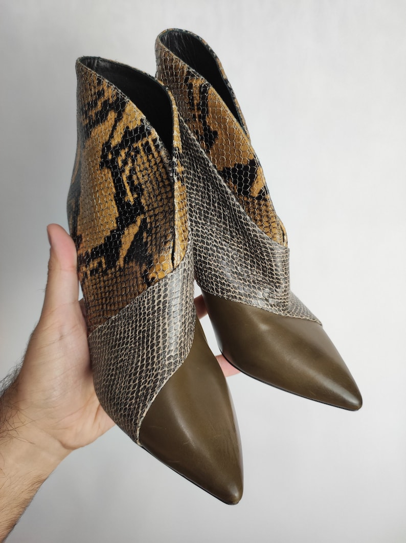 May include: A pair of brown and black snakeskin ankle boots with pointed toes and a stiletto heel.