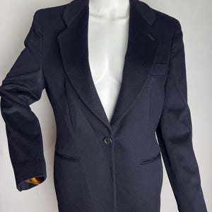 Pode incluir: Um blazer azul marinho com um fecho de bot&atilde;o &uacute;nico e uma lapela cl&aacute;ssica.
