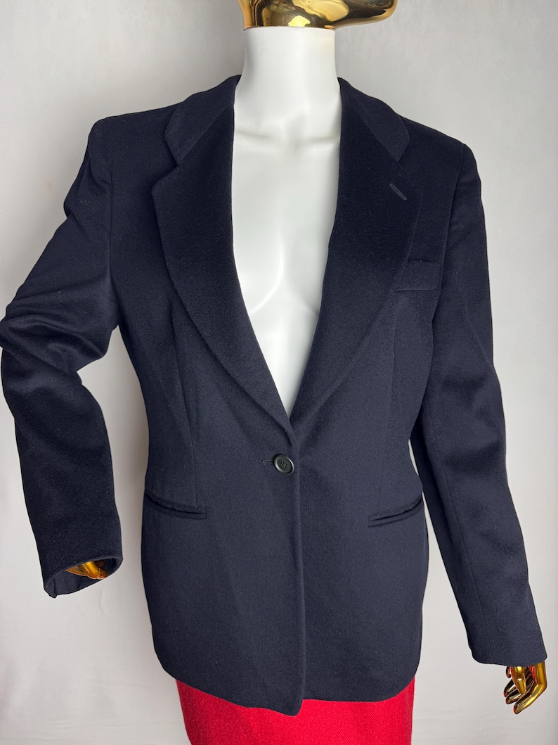 Pode incluir: Um blazer azul marinho com um fecho de bot&atilde;o &uacute;nico e uma lapela cl&aacute;ssica.
