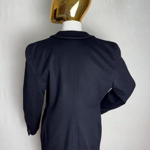 Pode incluir: Um blazer azul marinho com mangas compridas e um fecho de bot&atilde;o. O blazer tem um corte cl&aacute;ssico e ajustado.