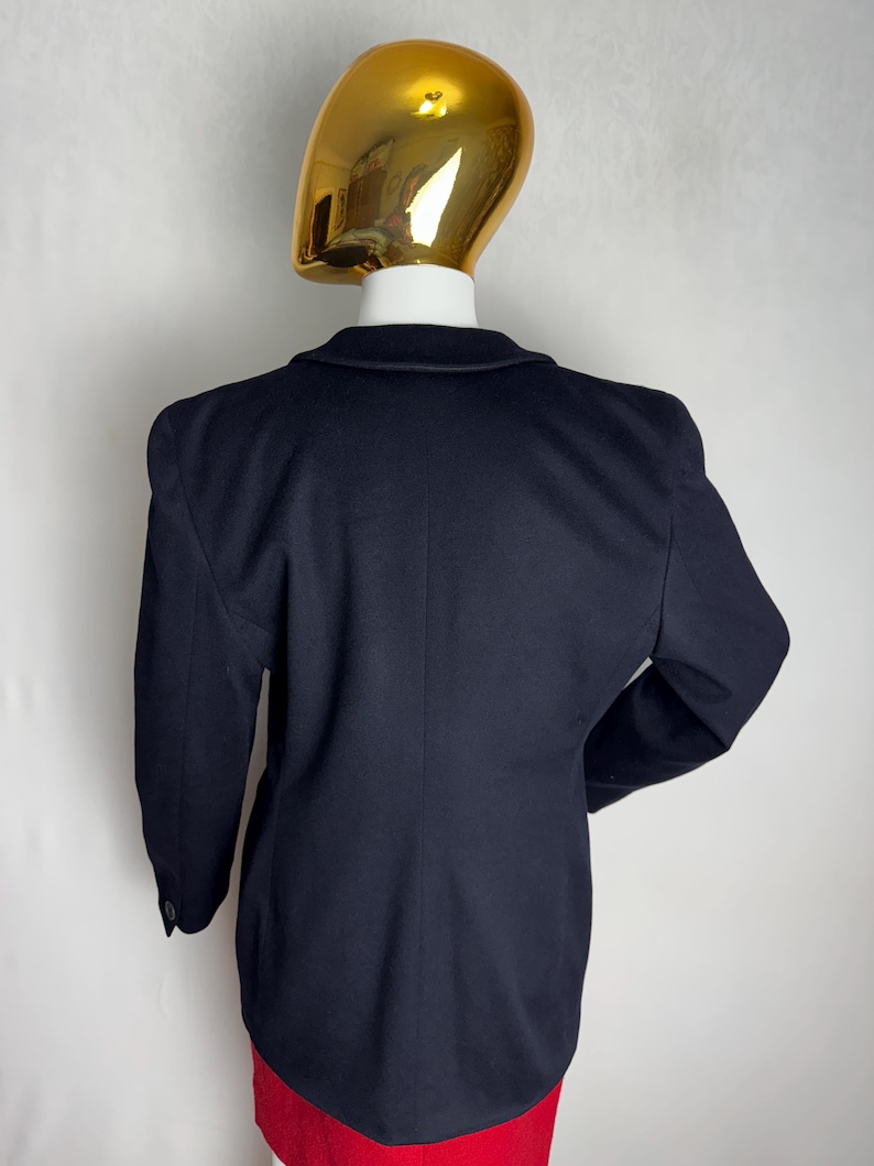 Pode incluir: Um blazer azul marinho com mangas compridas e um fecho de bot&atilde;o. O blazer tem um corte cl&aacute;ssico e ajustado.