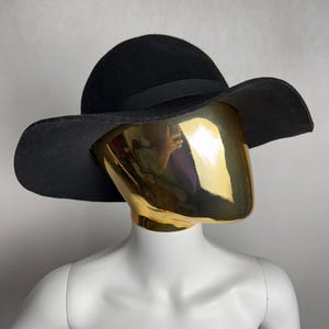 Puede incluir: Un sombrero de fieltro negro de ala ancha con una cinta negra alrededor de la corona.