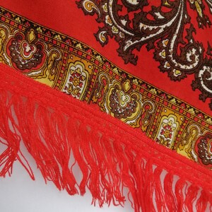 K&ouml;nnte beinhalten: Roter Stoff mit Paisley-Muster und rotem Fransenrand.