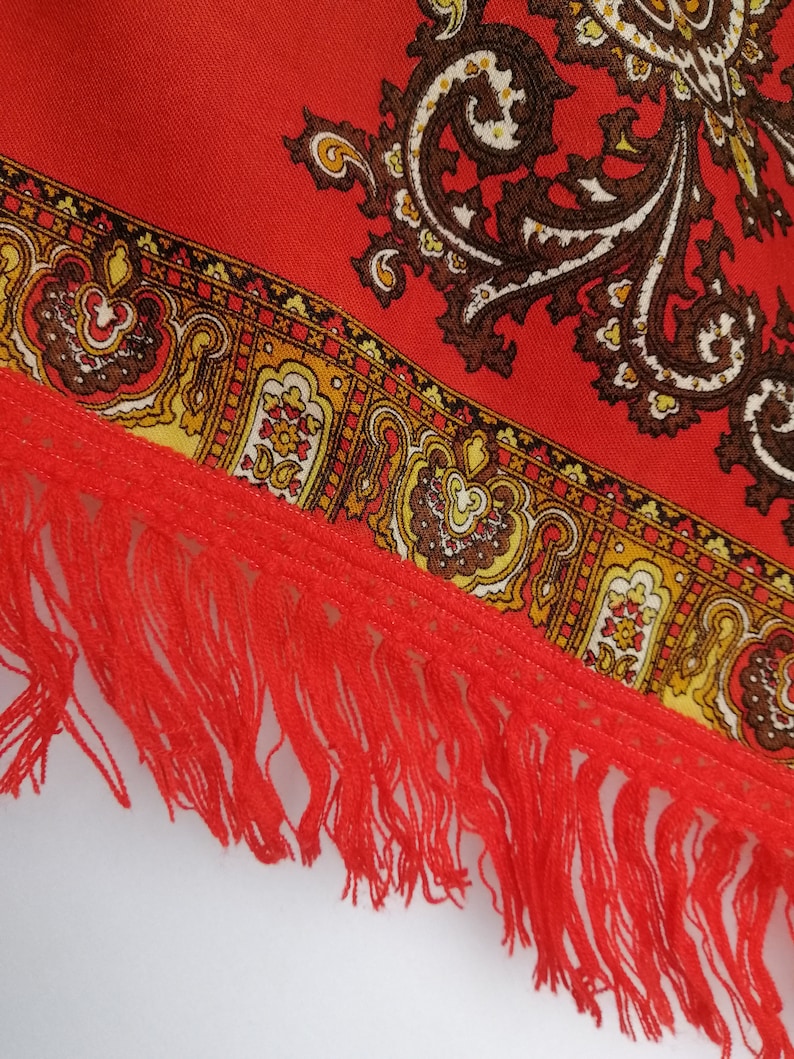 K&ouml;nnte beinhalten: Roter Stoff mit Paisley-Muster und rotem Fransenrand.