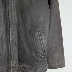 Puede incluir: Chaqueta de cuero marr&oacute;n oscuro con cierre de cremallera y un peque&ntilde;o bolsillo en el pecho. La chaqueta tiene un aspecto desgastado y texturizado y un dise&ntilde;o cl&aacute;sico. La chaqueta es de peso medio y adecuada para climas m&aacute;s fr&iacute;os.