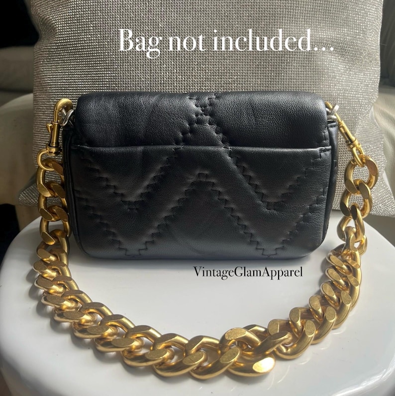May include: A black quilted leather handbag with a thick gold chain strap. The bag has a flap closure and a small pocket on the back. The text "VintageGlamApparel" is printed on the bottom of the image.