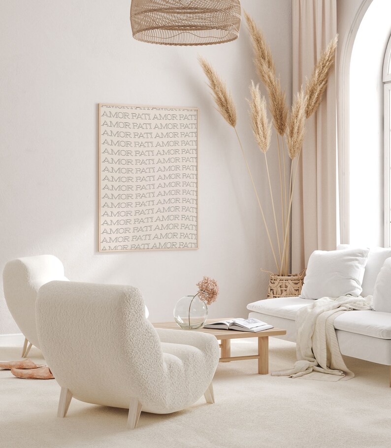 May include: A white living room with a white couch, two white fluffy chairs, a wooden coffee table, a vase with pink flowers, a wicker basket, and a framed print with the text "AMOR PATI AMOR PATI" repeated multiple times.