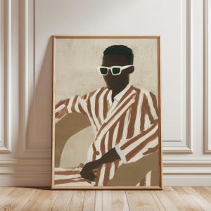 May include: A framed art print featuring a person wearing white sunglasses and a brown and white striped suit. The artwork has a neutral background and is displayed in a room with white molding and a wooden floor.