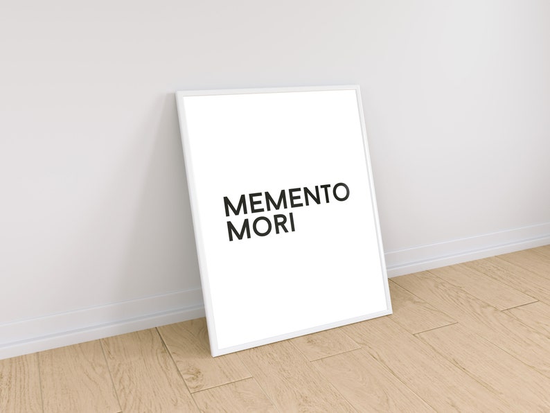 May include: A white framed print with the text "MEMENTO MORI" in black lettering.