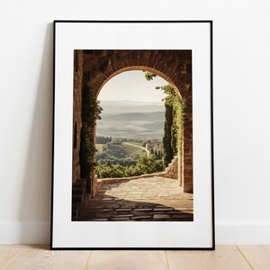Tuscan arch print: brick Italian archway framing a countryside valley with stone path and olive trees in oil painting style.
