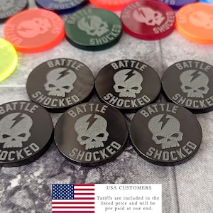 May include: A collection of colorful, circular game tokens. The tokens feature a skull and lightning bolt design with the words "BATTLE SHOCKED". The tokens are in various colors, including black, red, green, and yellow.
