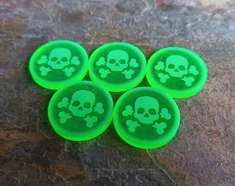 May include: Five green plastic game tokens with a white skull and crossbones design.