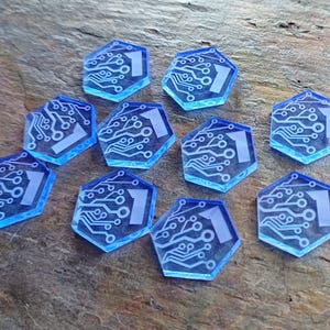 Könnte beinhalten: Zehn blaue sechseckige Spielsteine mit einem weißen Schaltkreisdesign und der Zahl "1" in der Mitte.