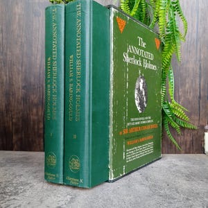 May include: Three hardcover books titled "The Annotated Sherlock Holmes" by William S. Baring-Gould. The books are green with gold lettering and a decorative emblem. The book on the right has a portrait of a man.