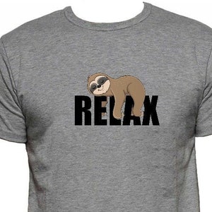 Puede incluir: Una camiseta gris con un dibujo animado de un perezoso con gafas de sol y la palabra "RELAX" impresa en negro.