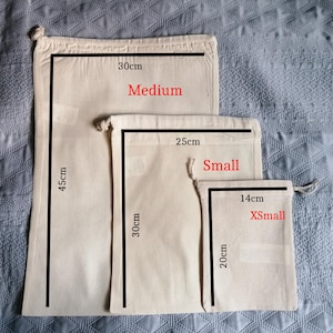 May include: Three cotton drawstring bags in different sizes. The largest bag is 30 inches by 45 inches and labeled "Medium". The middle bag is 25 inches by 30 inches and labeled "Small". The smallest bag is 14 inches by 20 inches and labeled "XSmall".