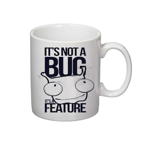 以下が含まれることがあります： 白地に黒と白の漫画の虫のイラストが描かれた白いセラミックマグカップ。テキストは「バグではなく、機能です」。