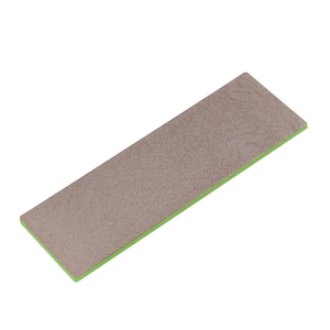 Puede incluir: Un acero de afilar rectangular gris con un borde verde. El acero se utiliza para afilar cuchillos.