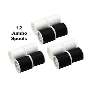 Może przedstawiać: Dwanaście dużych szpulek nici, z sześcioma białymi i sześcioma czarnymi szpulkami. Szpulki ułożone są w trójkąt na białym tle. Widoczny jest tekst "12 Jumbo Spools".