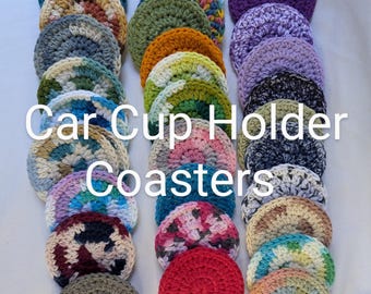 May include: A collection of colorful, crocheted car cup holder coasters. The coasters are round and feature various color combinations, including teal, orange, purple, and pink. The text "Car Cup Holder Coasters" is displayed across the image.