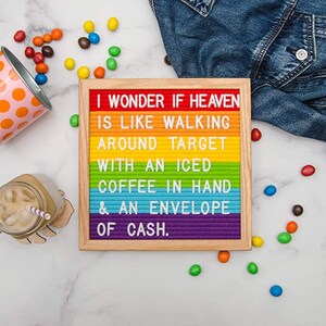 May include: A rainbow letter board with the message "I WONDER IF HEAVEN IS LIKE WALKING AROUND TARGET WITH AN ICED COFFEE IN HAND & AN ENVELOPE OF CASH."