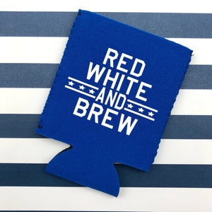 Op de afbeelding: Een blauwe neopreen-blikjeskoeler met witte tekst die "Red White and Brew" luidt met drie sterren boven en onder het woord "and".