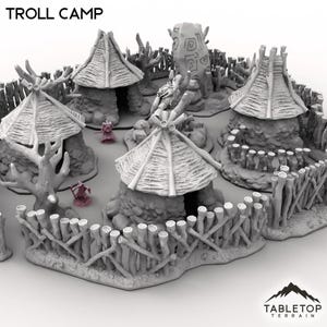 May include: A gray tabletop terrain set depicting a troll camp. The set includes three small huts with thatched roofs, a wooden fence, and a large carved stone. The text "TROLL CAMP" is at the top.