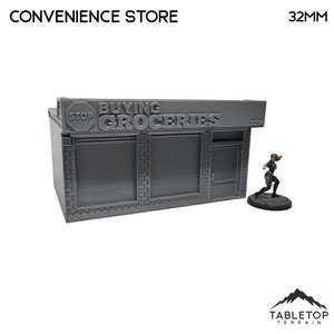 Puede incluir: Un modelo de tienda de conveniencia impreso en 3D gris con un letrero que dice "Buying Groceries" y una señal de "Stop". La tienda tiene dos ventanas y una puerta. El modelo mide 32 mm de alto.