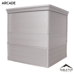 以下が含まれることがあります： グレーの3階建ての建物で、レンガ造りの土台と「ARCADE」と書かれた看板があります。