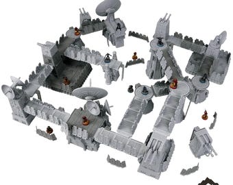 Op de afbeelding: Een grijze tabletop terreinset, met de tekst "VANGUARD STATION" bovenaan. De set bevat verschillende modulaire structuren, loopbruggen en schotelantennes. Kleine beeldjes zijn geplaatst, wat wijst op een spelomgeving. Het "TABLETOP TERRAIN" logo staat onderaan.