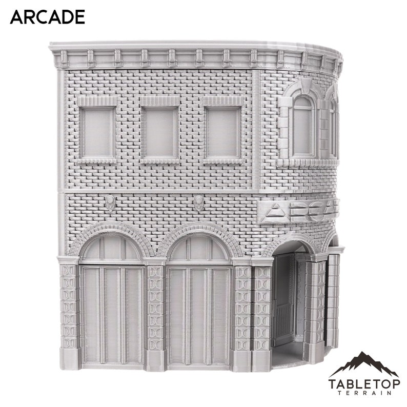 以下が含まれることがあります： アーケードと書かれた看板のあるレンガ造りの建物のグレーの3Dプリントモデル。建物にはアーチ型のドアと窓があります。このモデルはテーブルトップゲーム用に設計されています。