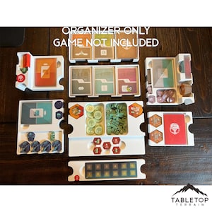 May include: White plastic organizer for the board game "The Crew: Mission Deep Sea". The organizer has compartments for cards, tokens, and other game components. The text "ORGANIZER-ONLY GAME NOT INCLUDED" is printed on the top of the organizer.