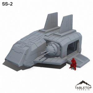 以下が含まれることがあります： ランプとランプの近くに立っている小さなフィギュアを持つ宇宙船のグレーの詳細なモデル。宇宙船は大きく丸いエンジンと2つの垂直な翼を持っています。モデルは「SS-2」とラベル付けされています。