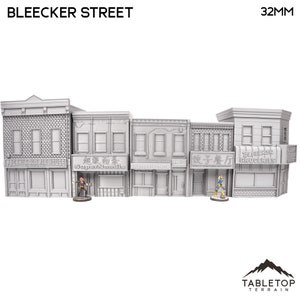 Puede incluir: Un conjunto de cinco edificios en miniatura grises a escala 32 mm con escaparates y letreros. Los letreros dicen "Paganis Old Ale House", "Super Noodle", "La Piccole Italia", "餃子餐厅" y "Bleecker Groceries".